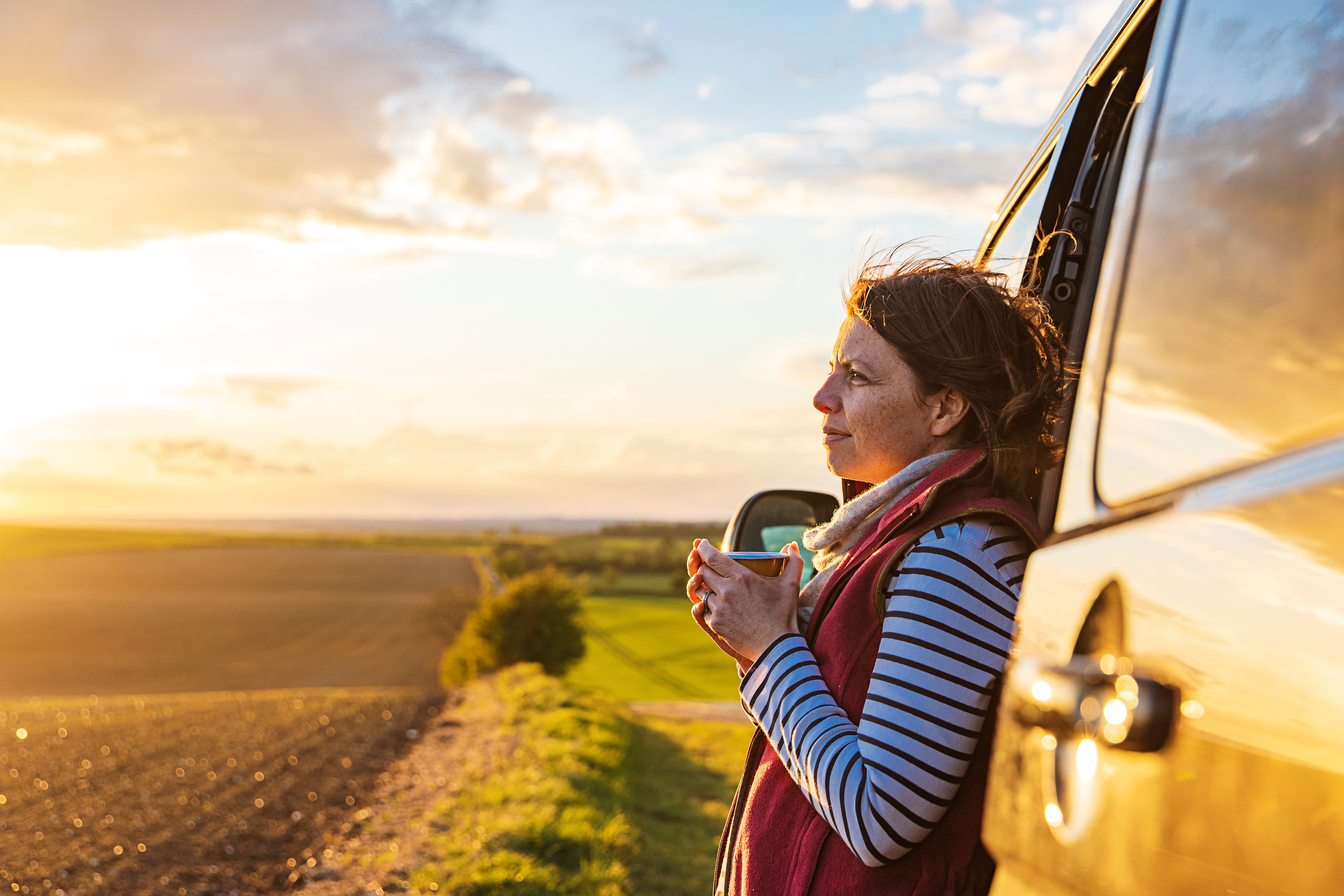 women outside holding a mug