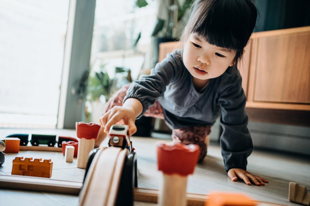A toddler playing with a wooden train set