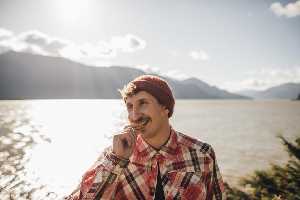 Man eating a cookie by a lake